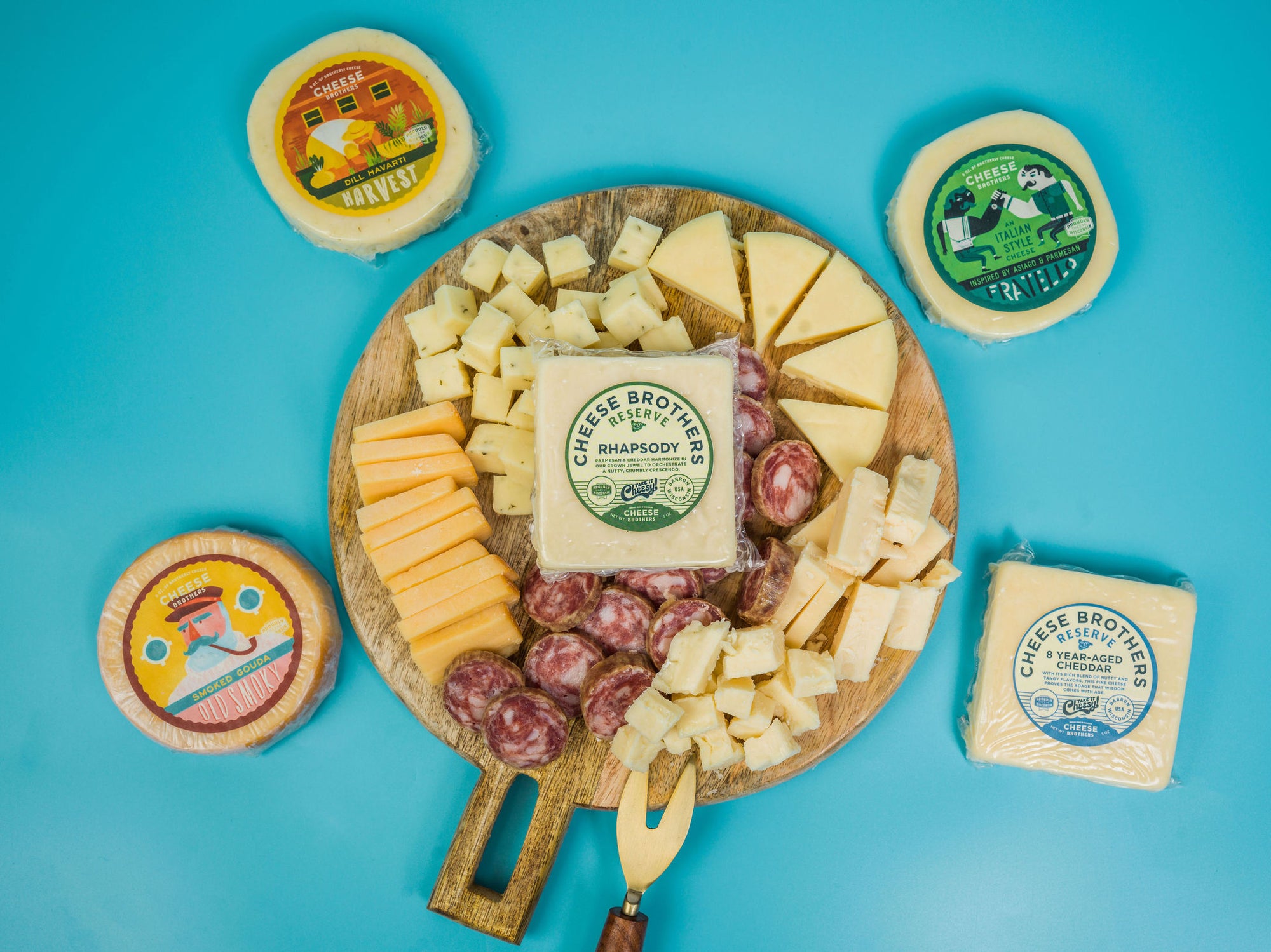 Charcuterie board with gourmet cheeses and sausage surrounded by packages.