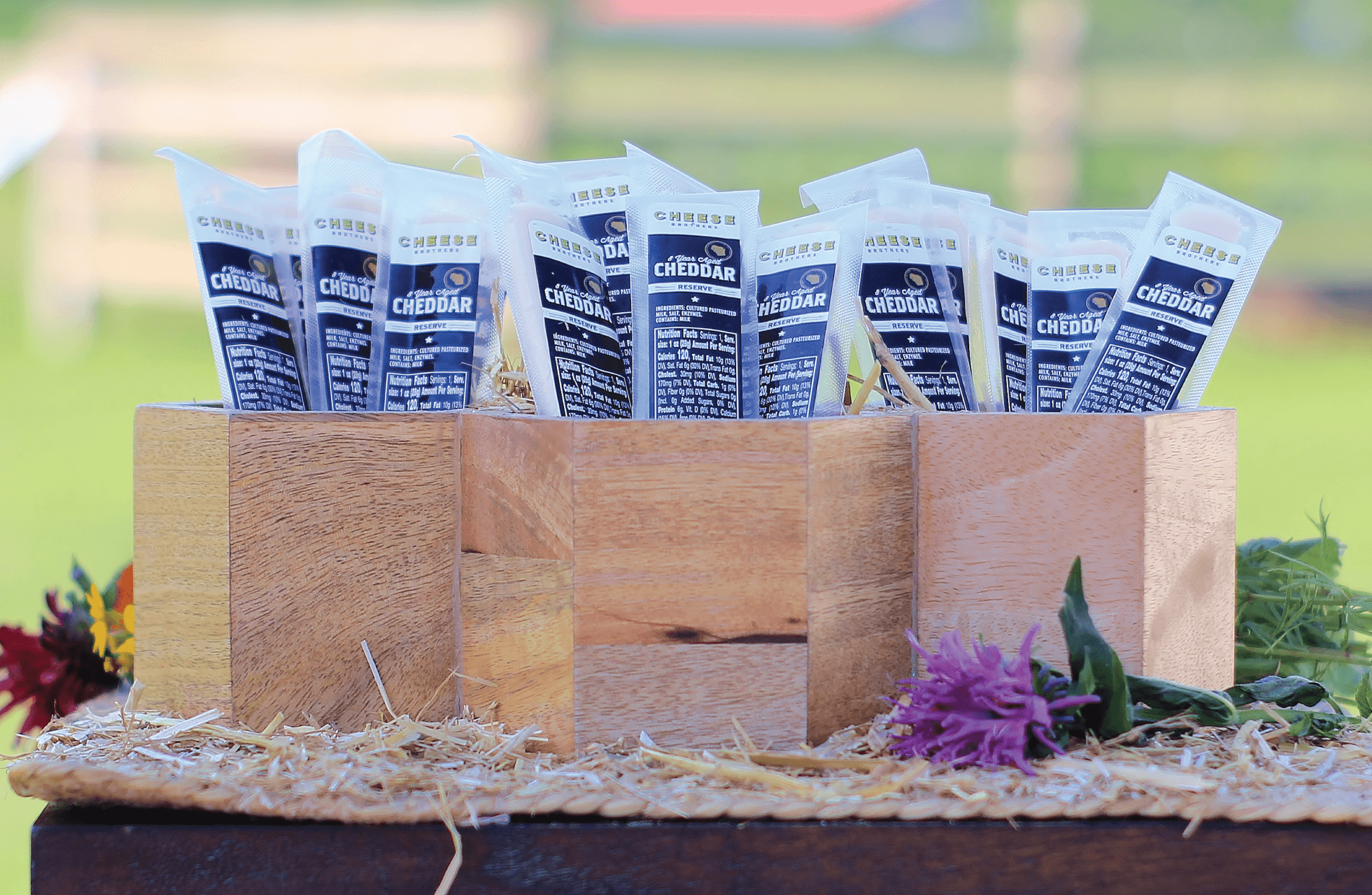 Three boxes filled with 8-year aged cheddar cheese sticks.