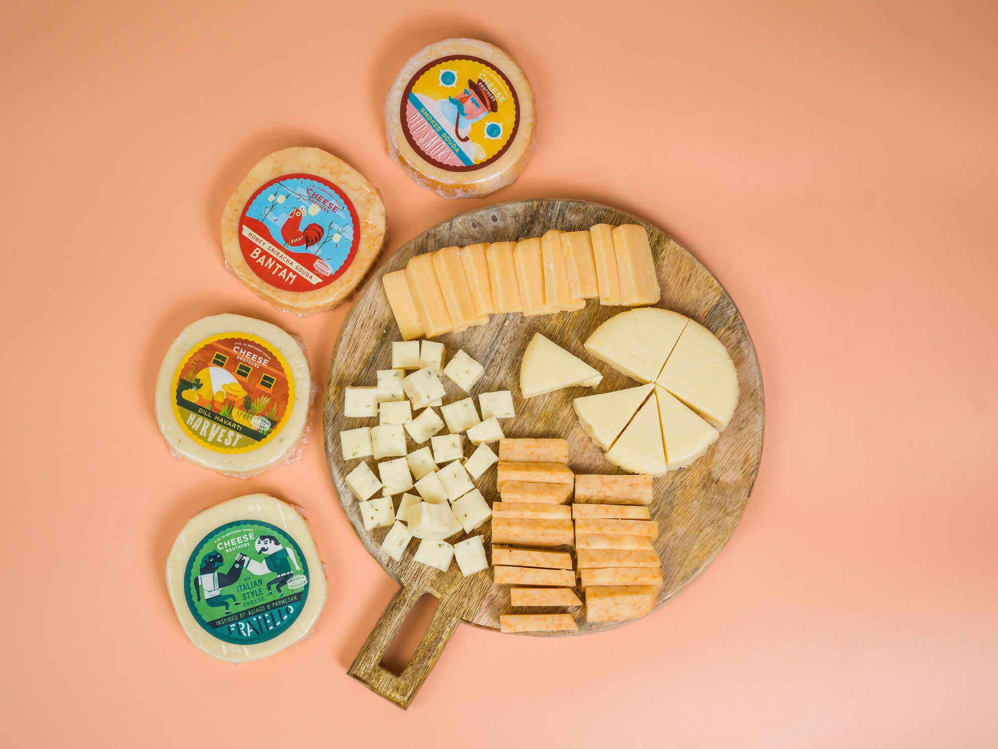 Charcuterie board with four packages of artisan Wisconsin cheeses.