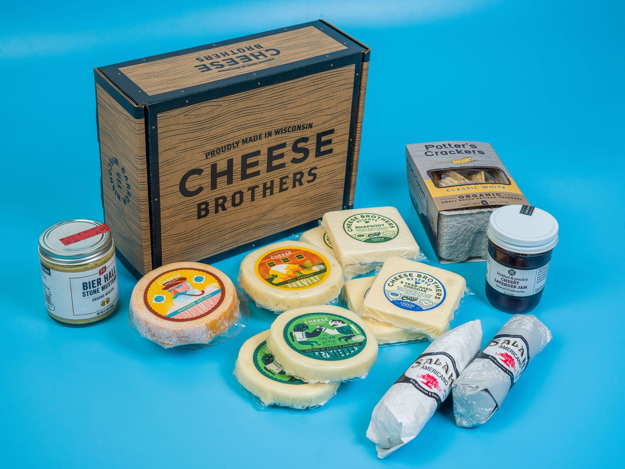 Cheese box with organic crackers, jam, salami, mustard, and five varieties of cheeses. 