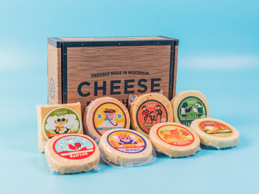 Eight varieties of Wisconsin artisan cheeses in front of Cheese Brothers box. 