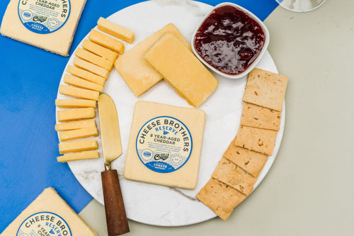 Package of 8-Year aged Wisconsin white cheddar on a charcuterie board. 