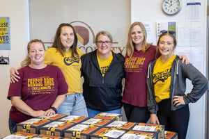 Cheese Sisters team in front of packaged cheese delivery boxes. 
