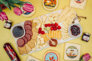 Aerial view of a plate with a variety of artisan Wisconsin cheeses, jams, honey, and berries. 