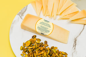 Back of package for Cheese Brothers gourmet parmesan with description and ingredients label on charcuterie board.
