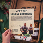 A 'Meet the Cheese Brothers' promo card being held up, it talks about Eric Ludy and Gene Graf - brotherhood of cheese.
