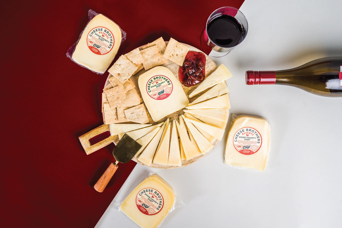 Package of door County duet gouda parmesan cheese on charcuturie board with glass of wine. 