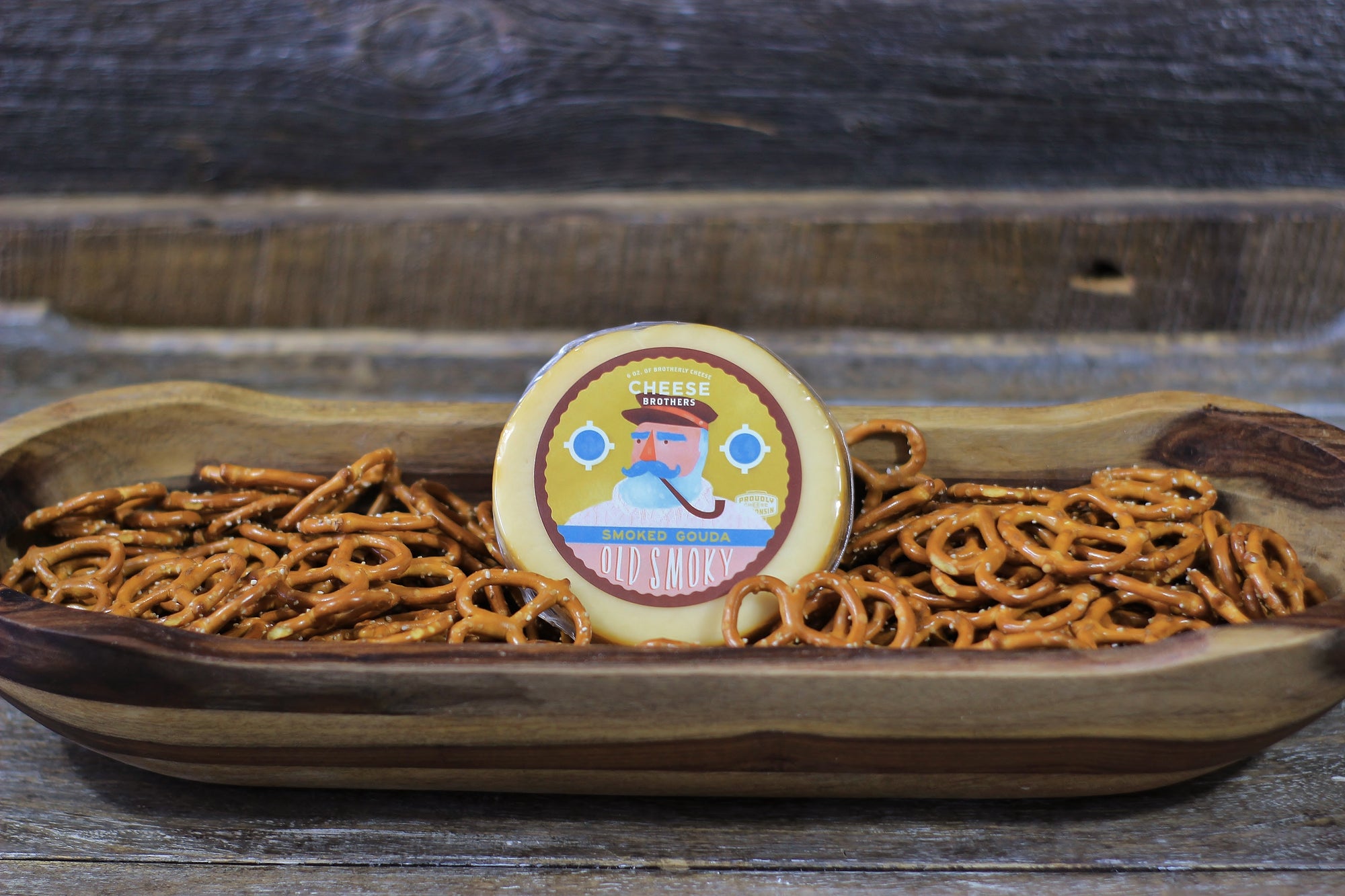 Package of Old Smoky artisan smoked gouda in a bowl of pretzels. 