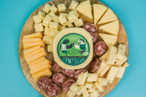 Package of Fratello asiago and parmesan cheese blend on a charcuterie board. 
