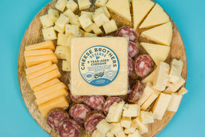 Package of 8-Year aged Wisconsin white cheddar on a charcuterie board. 