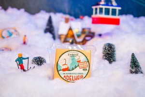 Package of Adelheid alpine-style cheese on top of a mountain chalet display. 