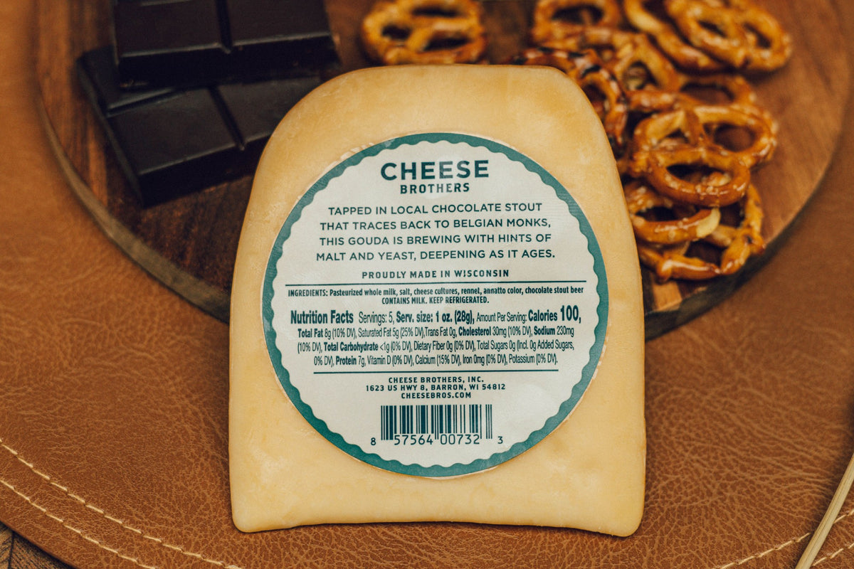 Back label for Cheese Brothers ale-washed gouda next to chocolate and pretzels. 
