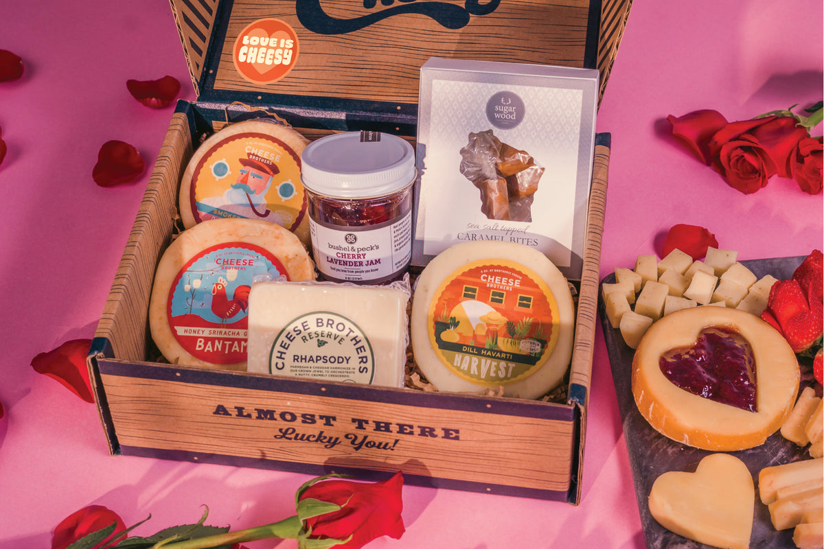 Inside Valentines Day gift box with four gourmet cheeses, jam, and caramels. 