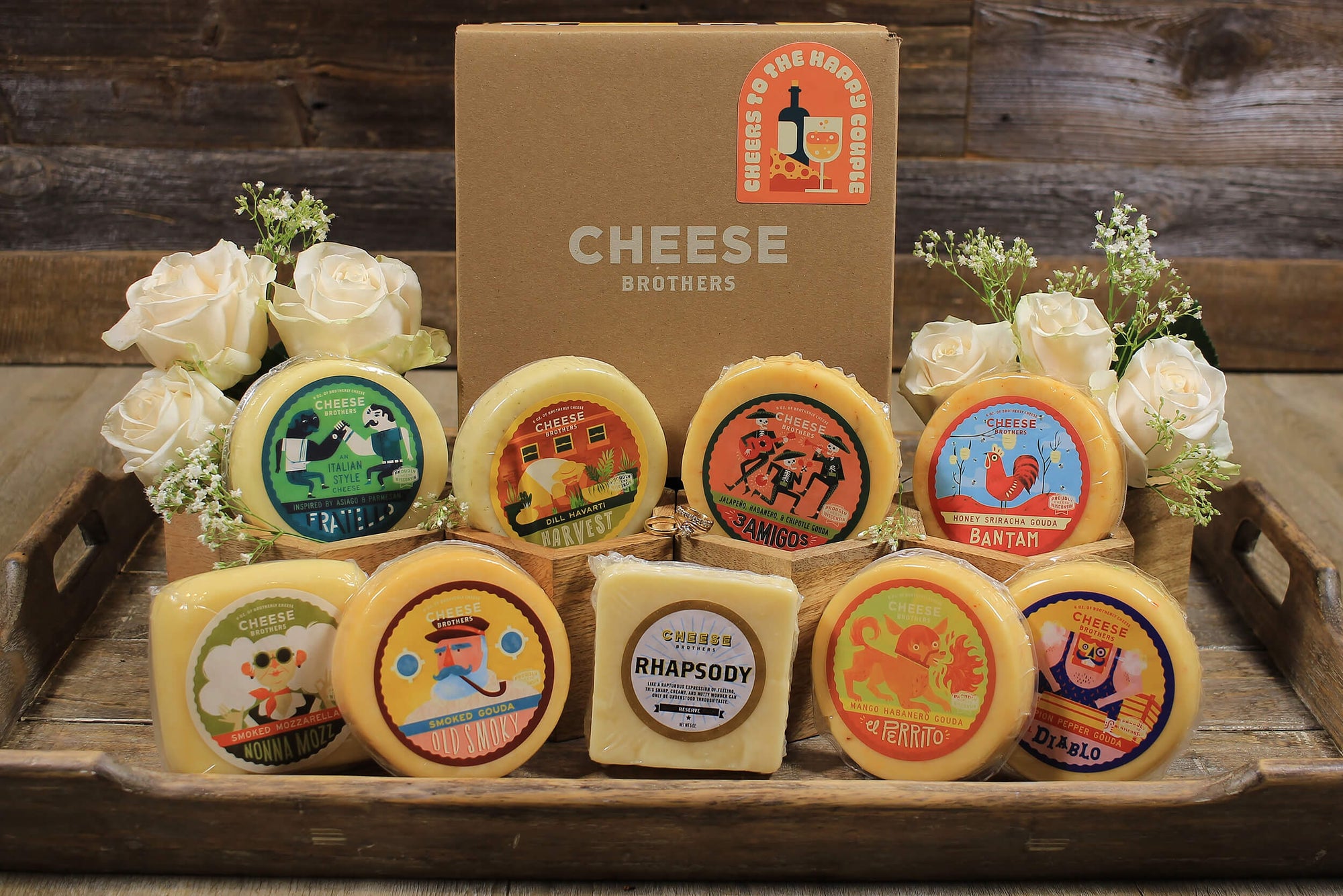 Wedding gift box with nine varieties of gourmet Wisconsin cheeses on a tray with white roses. 